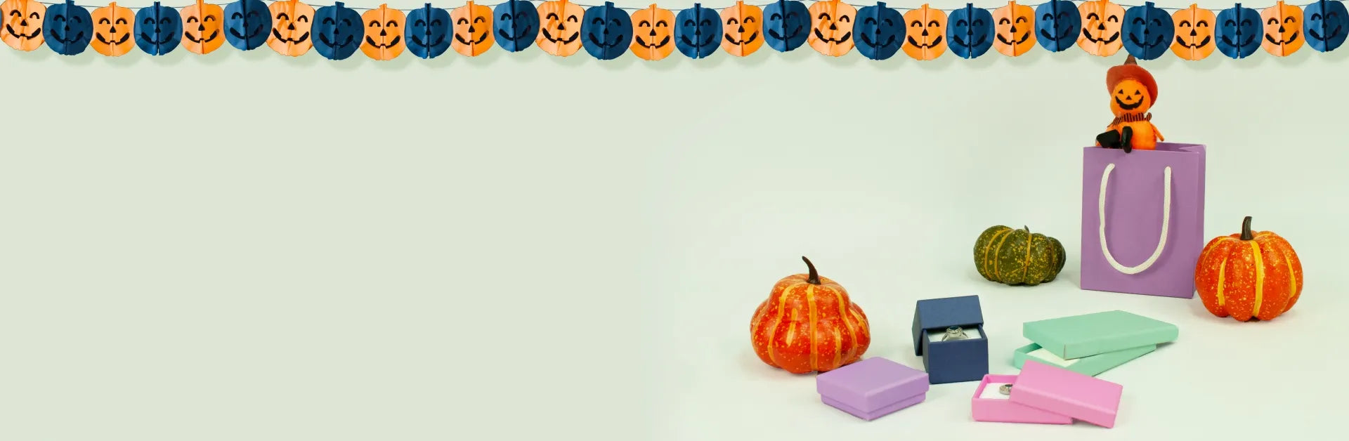 Halloween-themed items including pumpkins, gift bags, and decorative ribbons on a light background.