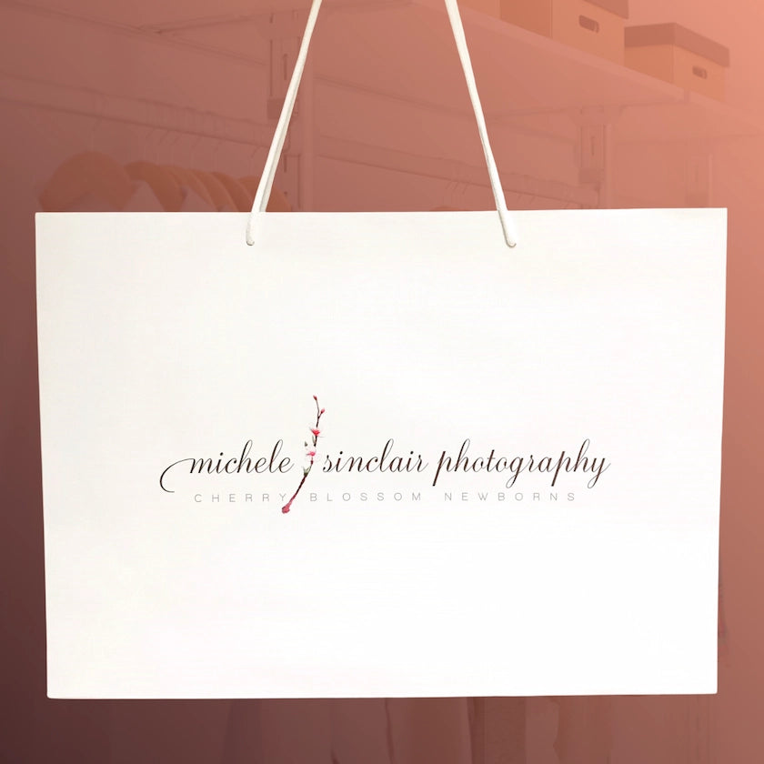 White bag with 'michele sinclair photography' logo on a blurred background