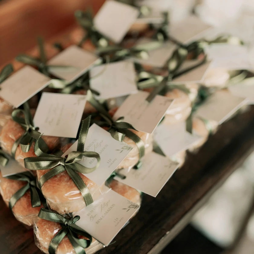 Elegant stacks of packaged Welsh cakes tied with green ribbons and cards, displayed on a wooden surface, conveying a warm, rustic gift vibe.