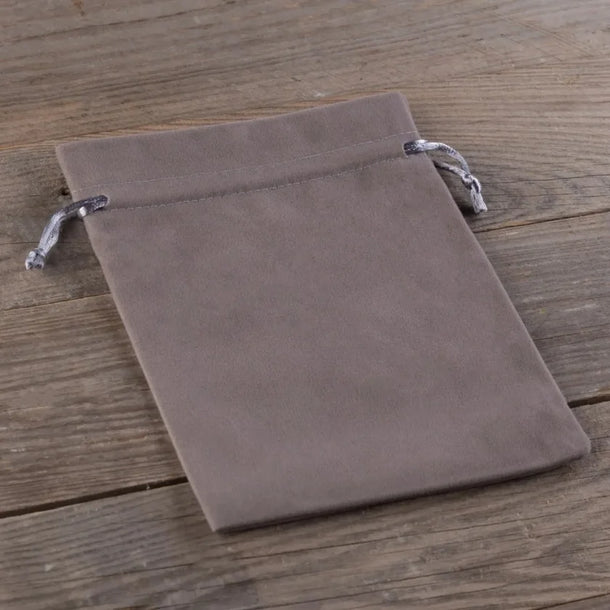Grey velvet drawstring pouch on a wooden surface.