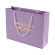 Purple paper bag with 'Packaging World' text and white handles on a white background