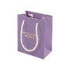 Purple gift bag with white handles and 'Packaging World' branding on a white background