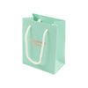 Green gift bag with white handles on a white background