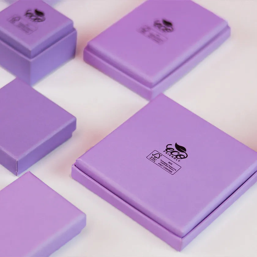 Purple gift boxes in various sizes arranged on a white surface. The boxes have an 