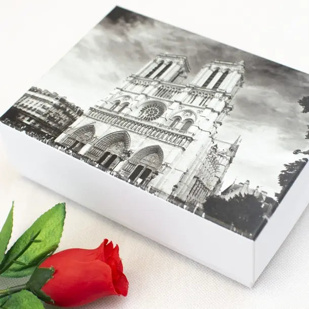 Box with a black and white architectural design on a white background with a red rose.