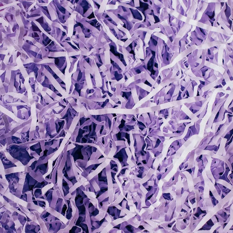 A dense pile of shredded, crinkled purple paper creates a textured, chaotic pattern. The pastel hue evokes a sense of whimsy and lightness.