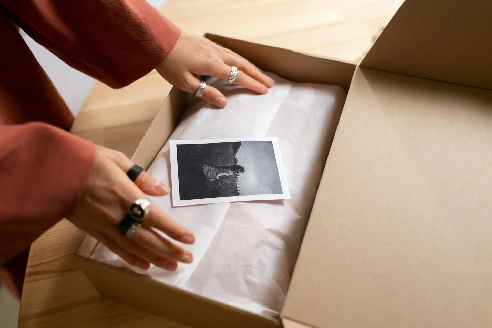 Open box with a polaroid photo, sitting on top of a tissue wrapped present