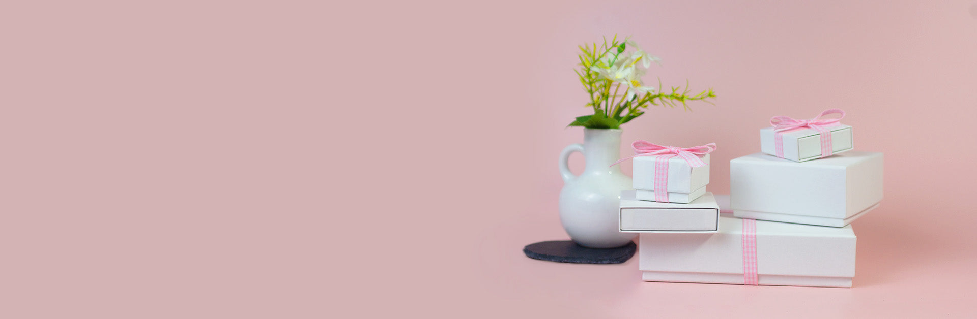 A white gift box with a pink ribbon and a decorative vase, designed for Mother's Day celebrations